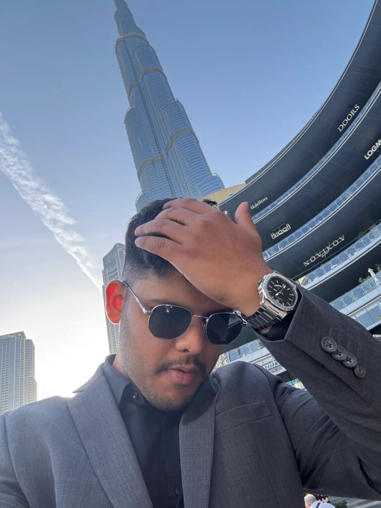 Man in suit and sunglasses posing with Burj Khalifa