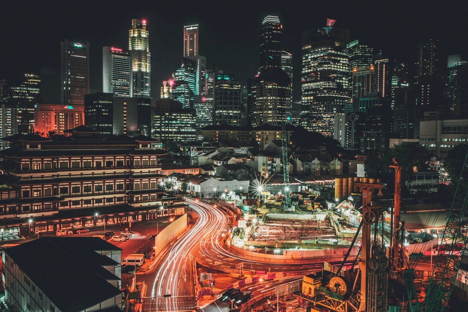 Vibrant city skyline at night with illuminated buildings and light trails